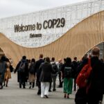 Participants walk by an entrance of COP29, UN Climate Change Conference venue, an event held by UNFCCC in Baku Olympic Stadium.