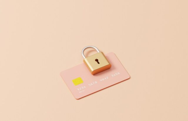 Studio image of a padlock on top of a credit cardchampagne coloured background, could symbolize ideas around encryption, credit card safety, security and passwords