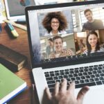 a person at a laptop talking to people on a zoom call