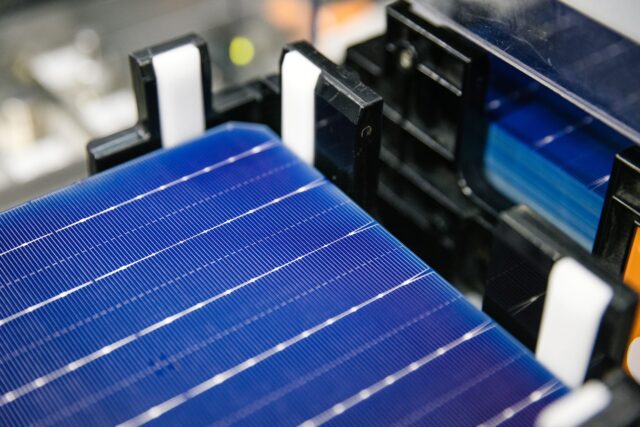 Close-up image of a deep blue solar panel with silver horizonal lines on it, on black equipment