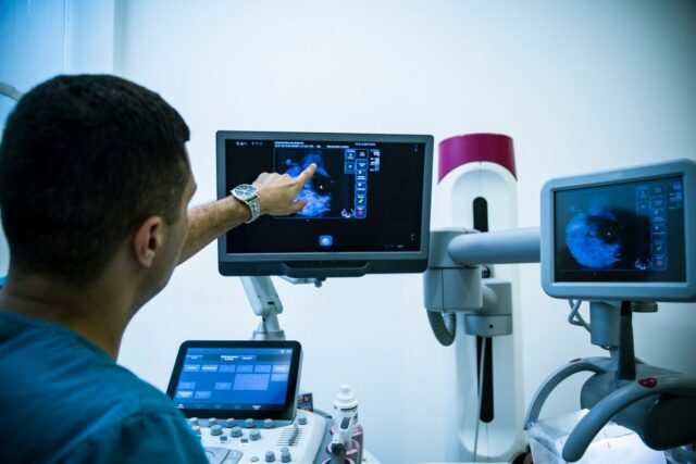 Doctor examining breasts with mammogram