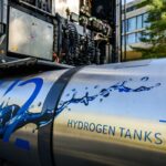 A hydrogen tank sits attached to an idle semi truck.