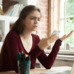 Annoyed frustrated woman having problem with not working mobile phone