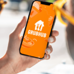 Grubhub app/logo displayed on a smartphone phone held in hand