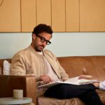 man sitting on couch, reading