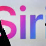 An image of a woman holding a cell phone in front of the Siri logo displayed on a computer screen.