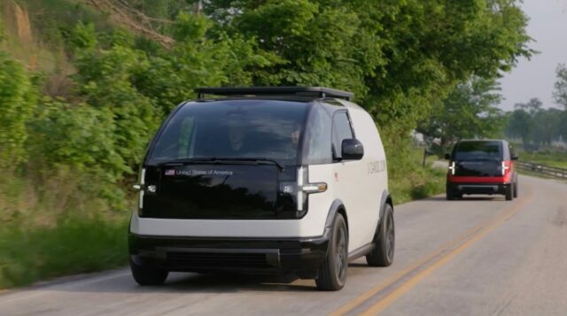 Two Canoo EVs drive on a road in Bentonville, Arkansas.