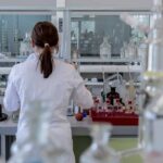 Female researcher from behind working in science laboratory.