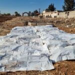 body bags lie on a field after a mass grave was discovered on agricultural land in izra in syria s southern deraa province photo afp