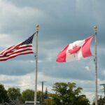 US and Canadian flags flying next to each other.