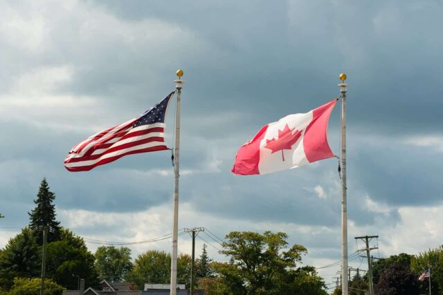 US and Canadian flags flying next to each other.