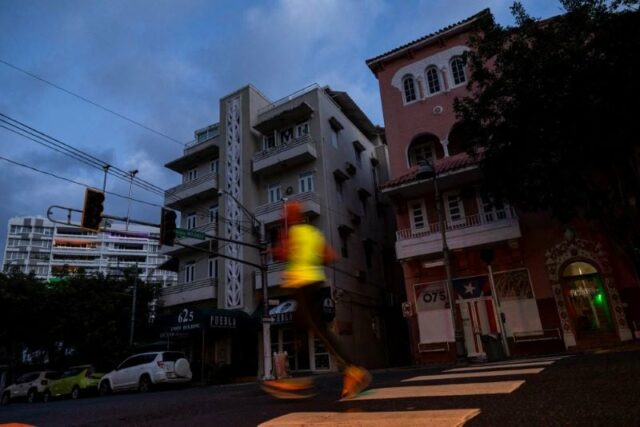 a man jogs on a dark street in san juan puerto rico after a major power outage hit the island tuesday photo afp