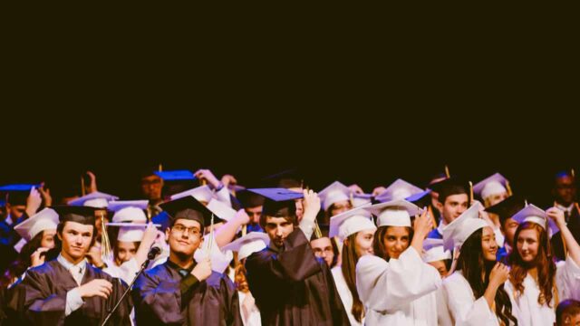 Group of graduating students wearing university gowns.