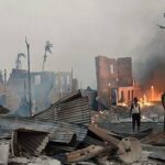 a man stands near a burning house at the site of a suspected air strike carried out by myanmar s military at kyauk ni maw village in western rakhine state photo afp