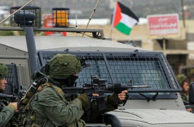 an israeli soldier takes aim during clashes with palestinian youths in the village of qabatiya near the west bank town of jenin photo afp