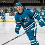 Fabian Zetterlund in der Luft, Jake Walman am Boden, während sich die San Jose Sharks auf den Flug nach Utah vorbereiten