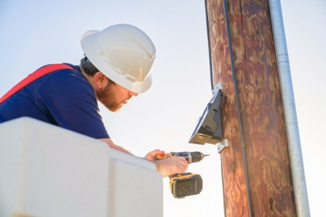 Tim Barat installs a Gridware device on a power line.