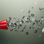 Red megaphone and silver colored alphabet letters in front of gray wall. Horizontal composition with copy space. Great use for announcement concepts.