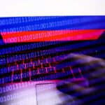 Russian flag displayed on a laptop screen and binary code code displayed on a screen are seen in this multiple exposure illustration photo