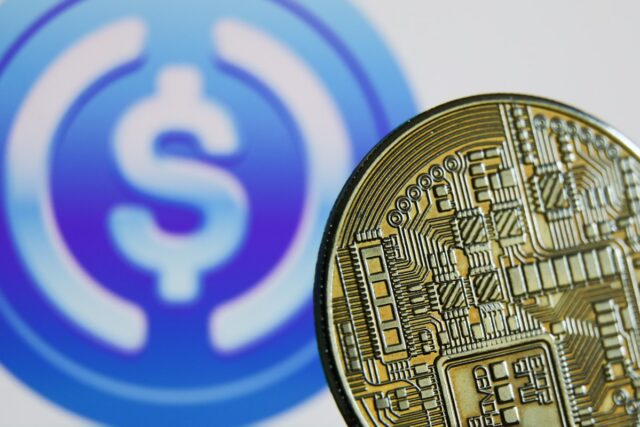 Representation of cryptocurrency and USD Coin logo displayed on a screen in the background are seen in this illustration photo taken in Krakow, Poland on June 10, 2022.