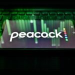 Peacock logo on a phone sitting on a keyboard