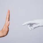 human hand raised rejecting robotic hand (concepts of human rejecting AI)