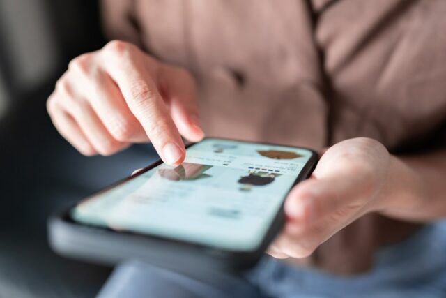 Woman's hands pointing to an item in an online shop on her smartphone, used in a post about FLIK