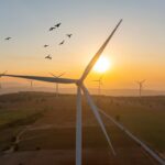 Wind turbine spins at sunrise.