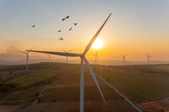 Wind turbine spins at sunrise.