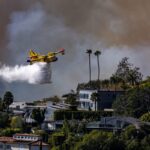 Pacific Palisades, CA - January 07: A Super Scooper plane drops water on the Palisades fire on Tuesday, Jan. 7, 2025 in Pacific Palisades, CA. (Brian van der Brug / Los Angeles Times via Getty Images)