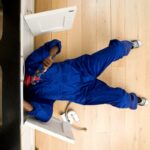 Plumber working under kitchen sink, overhead view