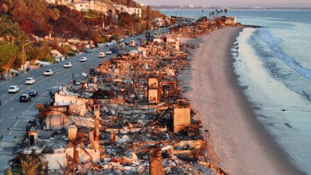 An aerial view of repair vehicles passing beachfront homes that burned in the Palisades Fire in Malibu, California.