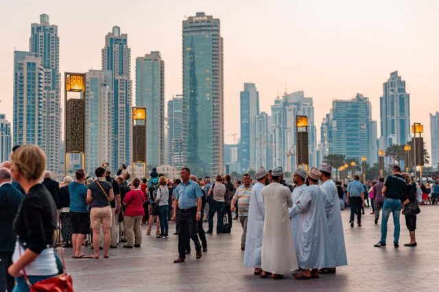 People in Downtown Dubai in front of cityscape.