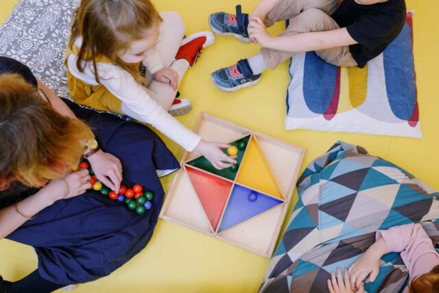 View from above of children playing with nursery teacher.