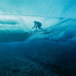 French surfer Joan Duru is glimpsed through the waves while competing in the 2024 Olympic Games in in Teahupo