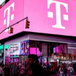 a t-mobile store in NYC in Times Square with bright pink lights on a billboard with T-Mobile's logo