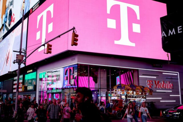 a t-mobile store in NYC in Times Square with bright pink lights on a billboard with T-Mobile's logo