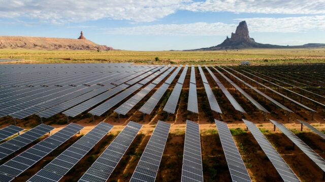 In an aerial view, the Kayenta Solar Plant is seen on June 23, 2024 in Kayenta, Arizona, with mountains in the background.