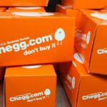 A collection of orange boxes with Chegg branding on a table.