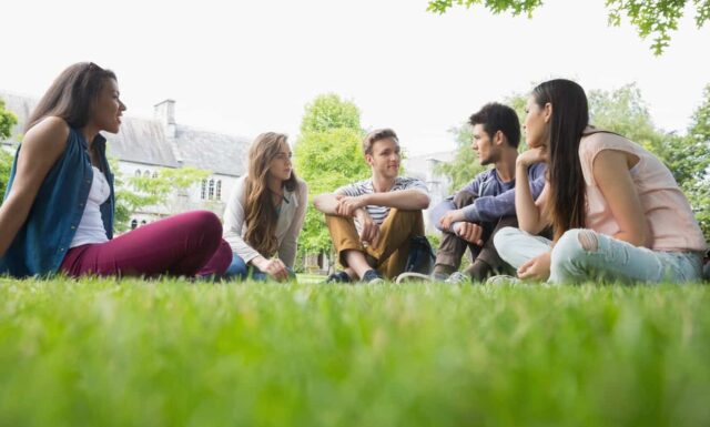 Happy students sitting outside on campus