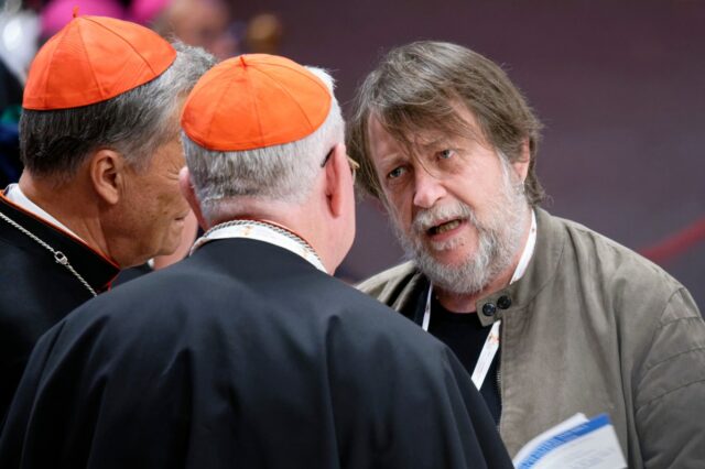 Luca Casarini, head of Mission of Mediterranea Saving Humans, talks with two cardinals before the vigil prayer in St. Peter's Basilica ahead of the start of the Synod of Bishops 16th General Assembly, at the Vatican, on October 1, 2024.