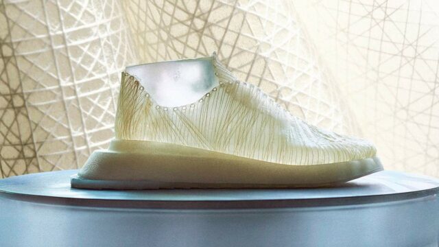 A shoe made of nanocellulose sits in front of a curtain.