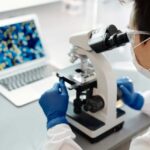 Female scientist looking into a microscope.